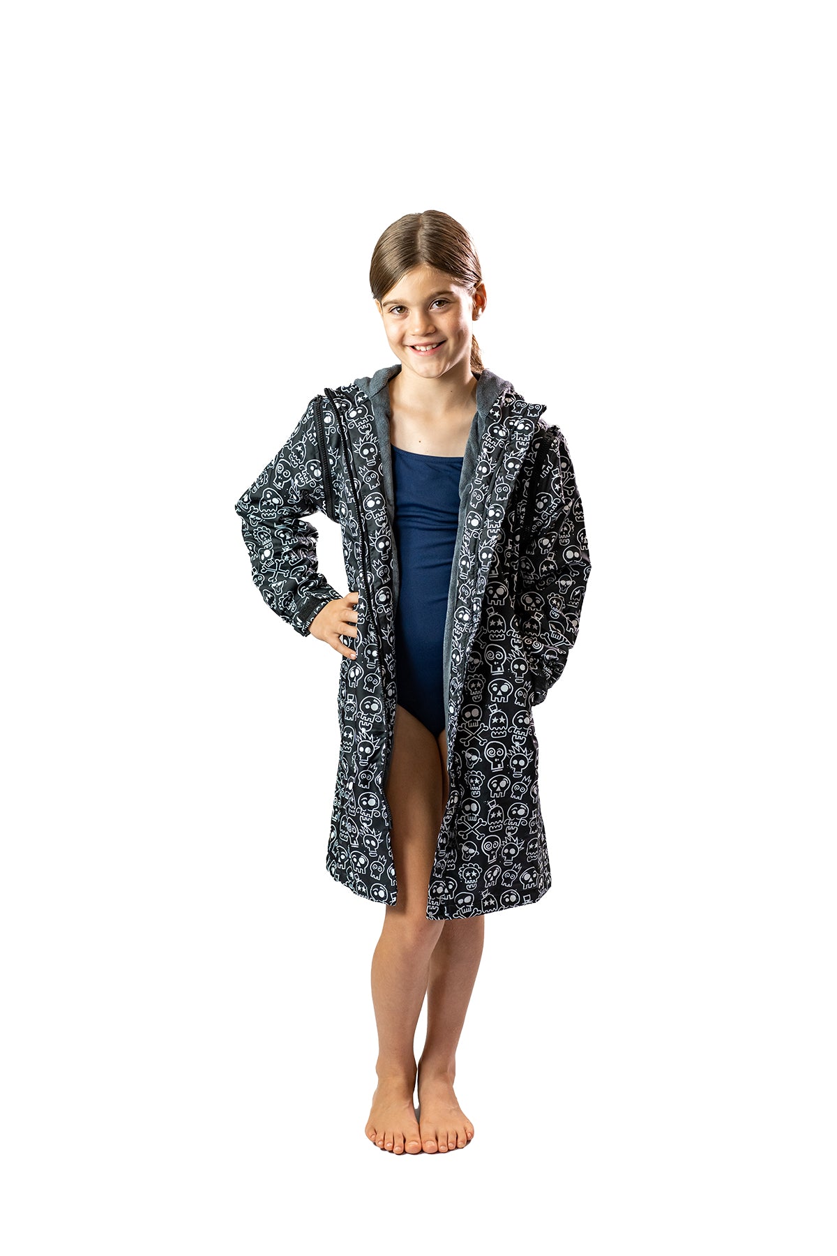 Girl standing wearing black skull and bones swim parka. Schmik skull swim parka.