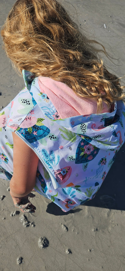 Sea Haven parka by schmik with removable sleeves. Girl bending over on beach. 80 mile beach Western Australia. 