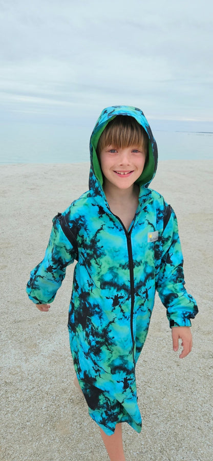 Child wearing Neon Dream wearable towel parka after swimming or surf lessons