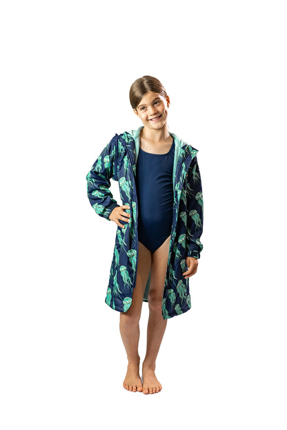 Child wearing swimmers and a schmik swim parka with jellyfish print. 