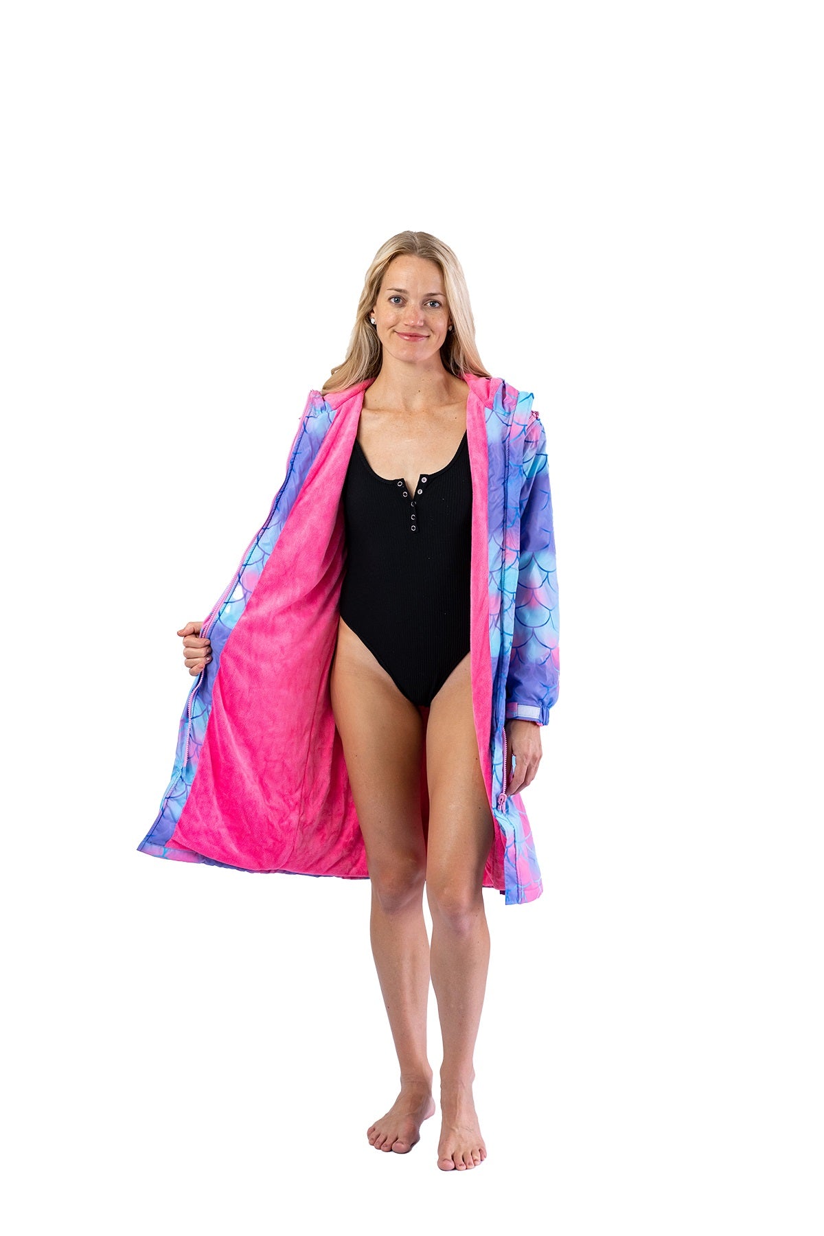 Adult wearing a small/ medium mermaid print swim parka. Mermaid parka is pink with mermaid scale printed over it. 