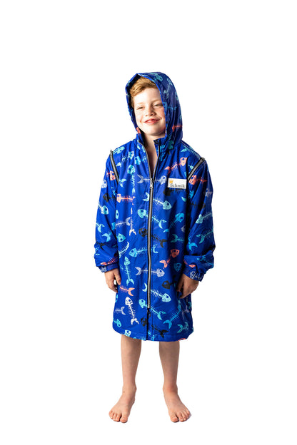 7 year old boy wearing a size 10 schmik swim parka in fishbone print with blue colour. Fitted hood is on boys head and comes with removable arms,