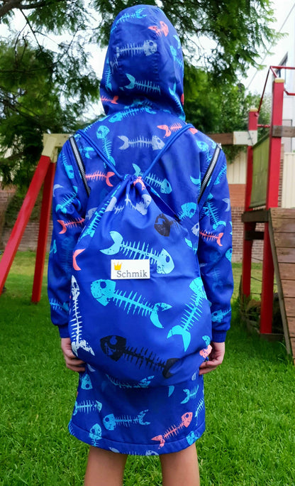 Child wearing matching blue fihbone print swim parka and blue fishbone print swim bag. 